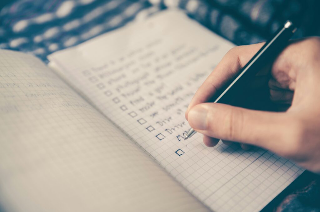 Person writing action steps in a notebook